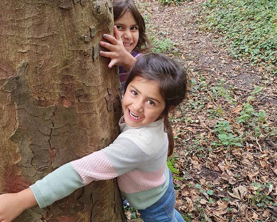 Two children hugging a tree