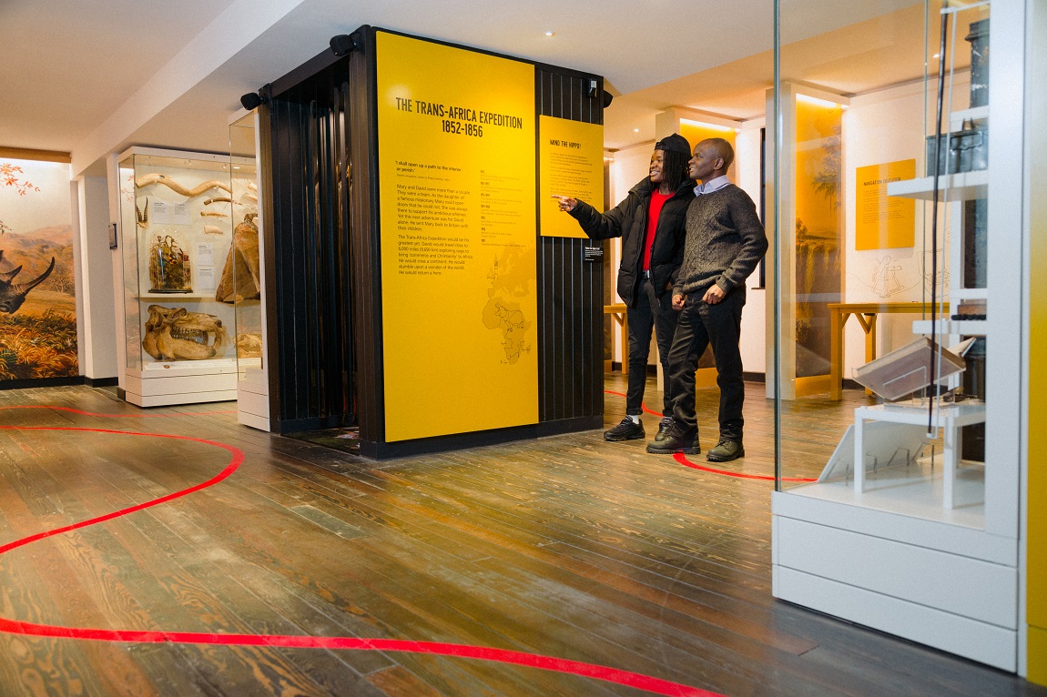 Two people inside a museum, pointing and interacting with the exhibition 