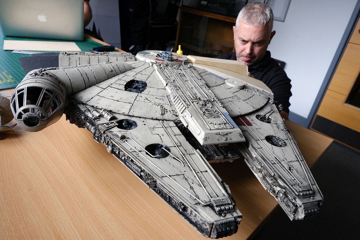A person working on a sculpture of the Millennium Falcon.