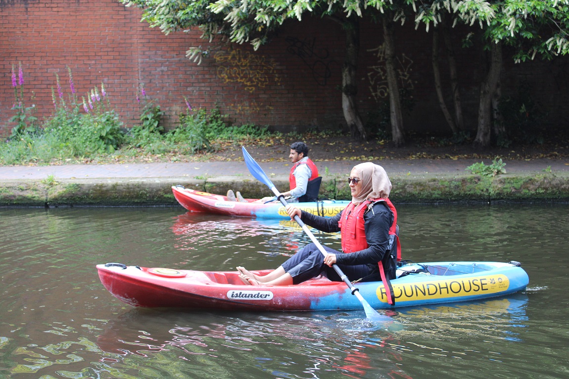 Two people kayaking on a canal 