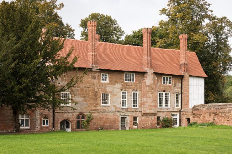 The exterior of Charterhouse in Coventry, a red sandstone building with many chimneys and windows