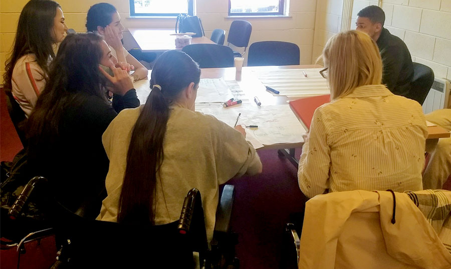 A group of people sitting around a table, contributing to a focus group