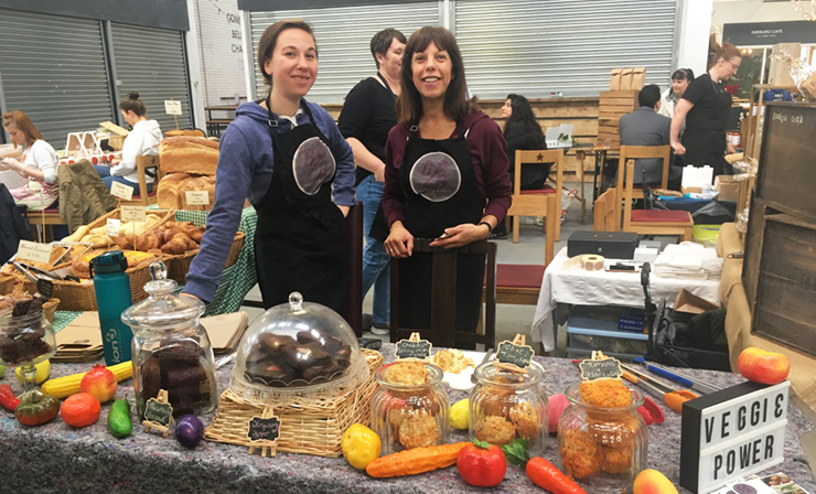 Two women standing behind a market stall