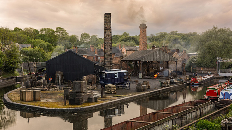 Long shot of museum with industrial chimneys, canal and boats