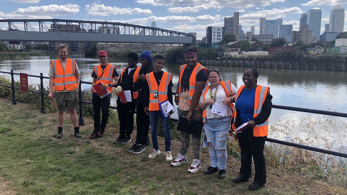 Group of young people standing in front of river