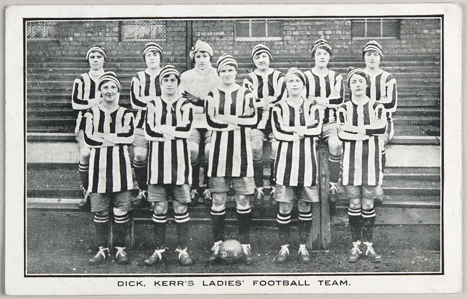 Women's football team stand in two rows, posing for camera photo