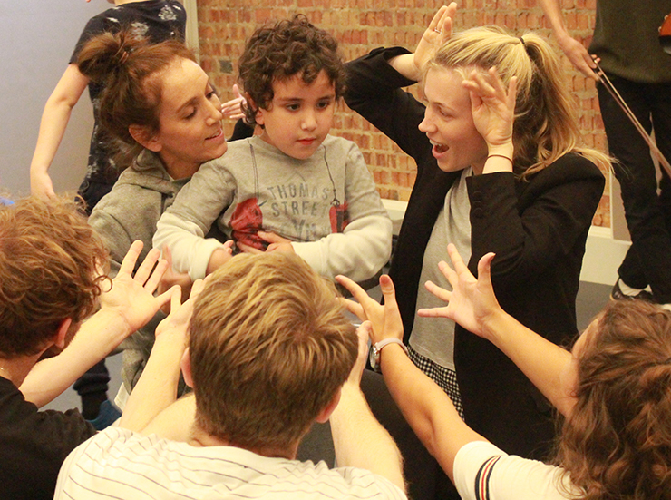 A child surrounded by adults in a theatre setting