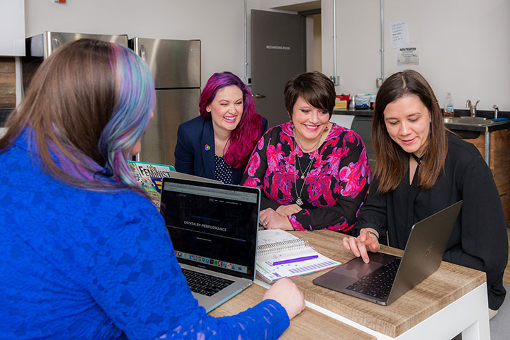 Four women working on laptops together