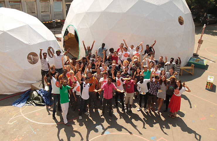 A crowd wave in front of two geodesic domes