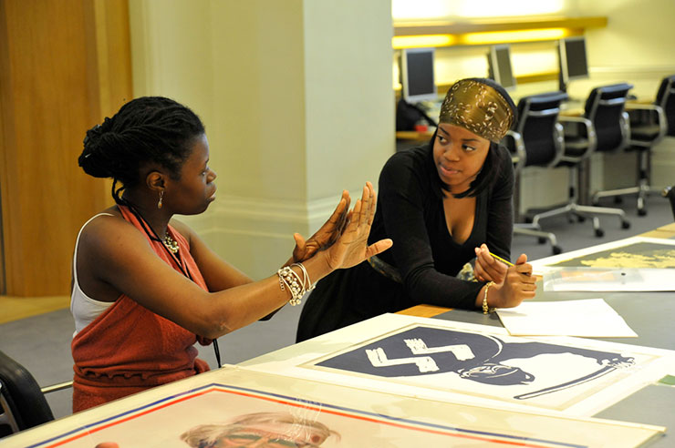 Two black museum staff working together