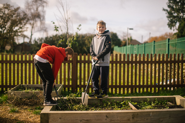 Two children digging in a garden