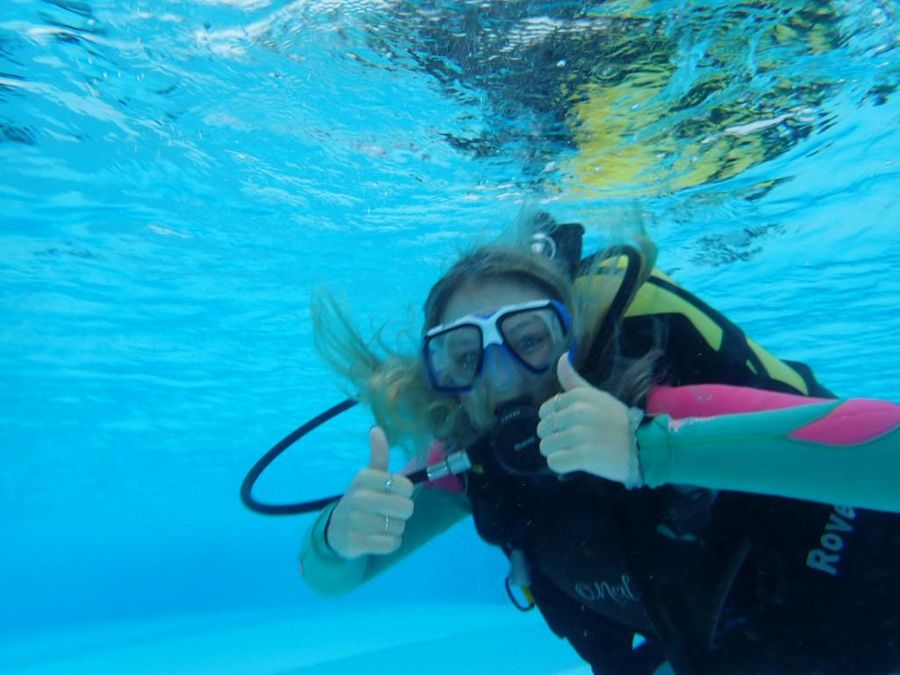 Image of girl scuba diving underwater giving thumbs up sign