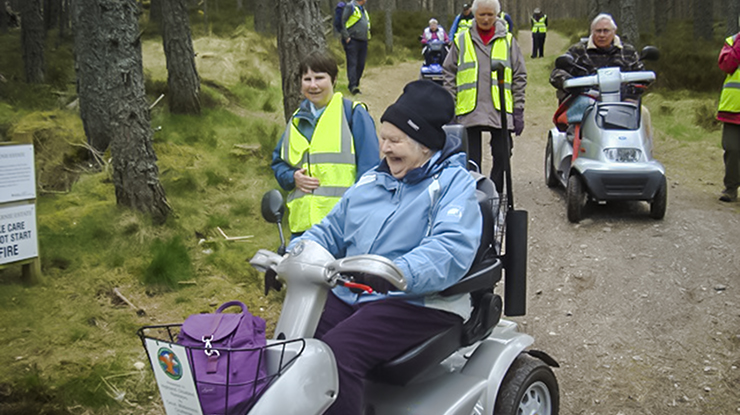 People on mobility scooters in woodland