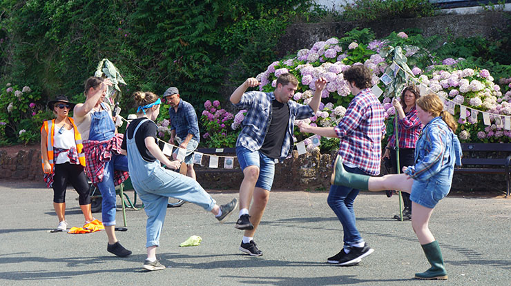 Young people dancing in a park with bunting