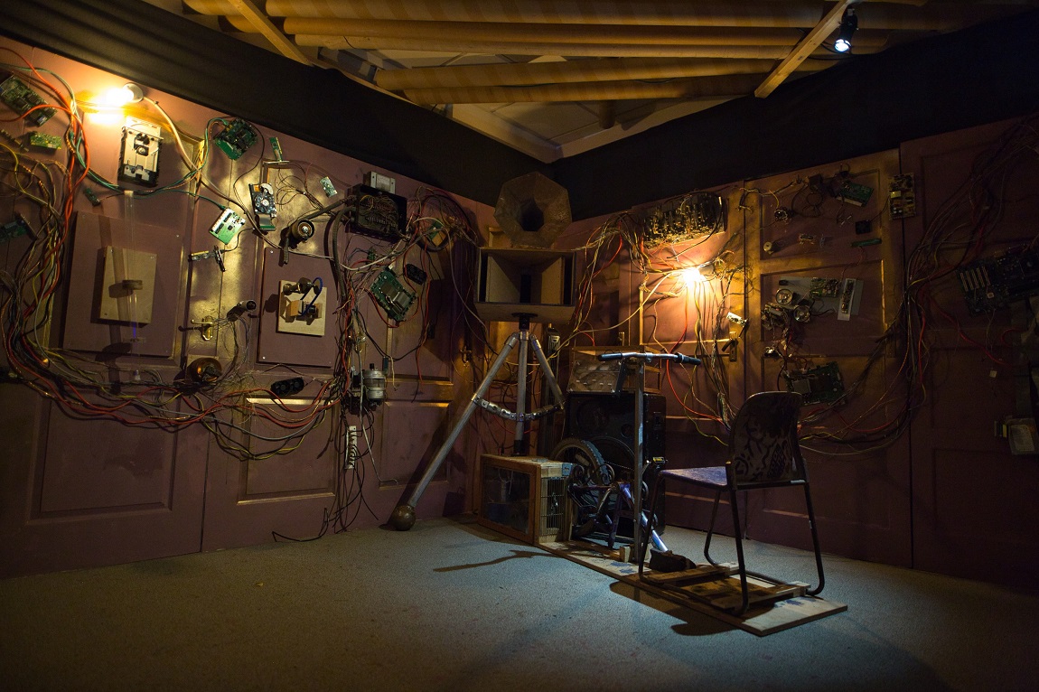 An art exhibiton room made out of old waste materials such as a bike, record player and old washing machine parts