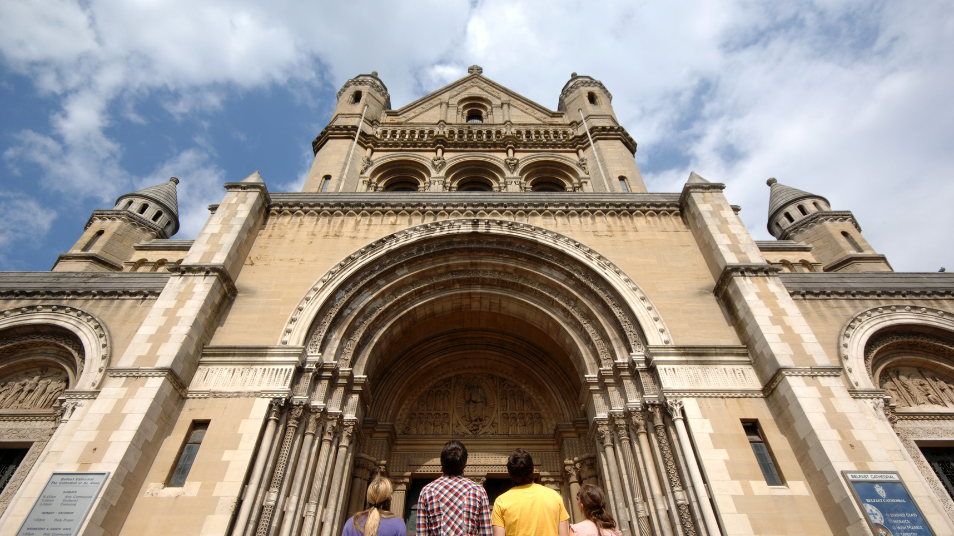 Group of people at the front of St Anne's Cathedral in Belfast looking up at the front of the building.