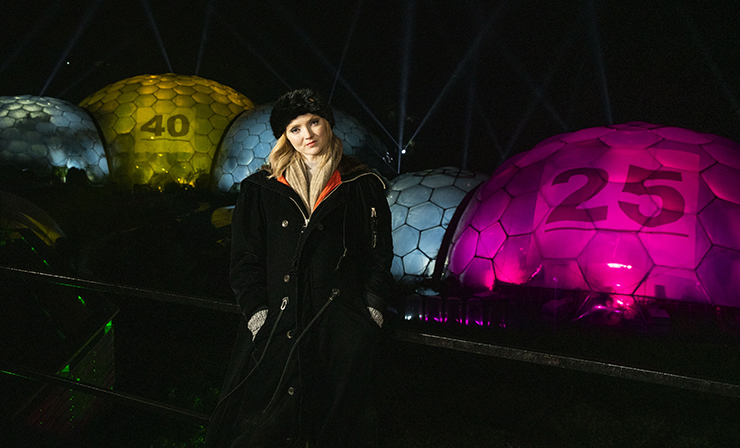 Lily Cole in front of the illuminated Eden Project Biomes