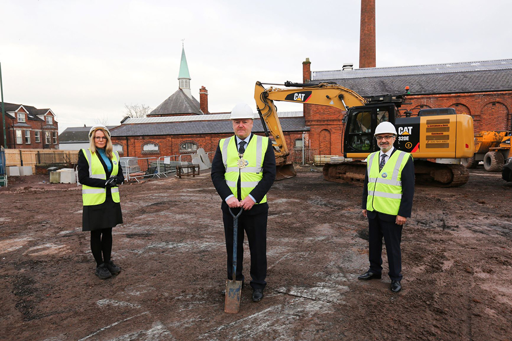 Three people standing in a building site