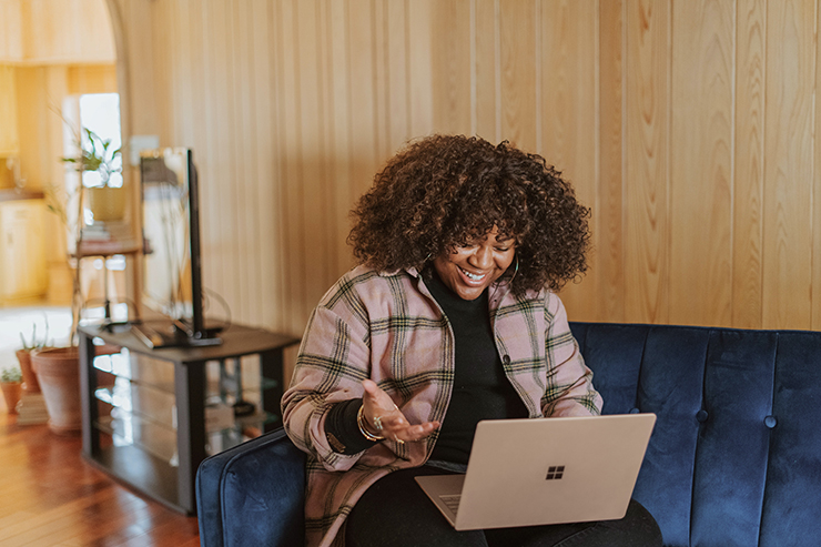 Woman working from a laptop on a sofa