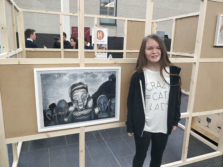 Girl standing next to painting