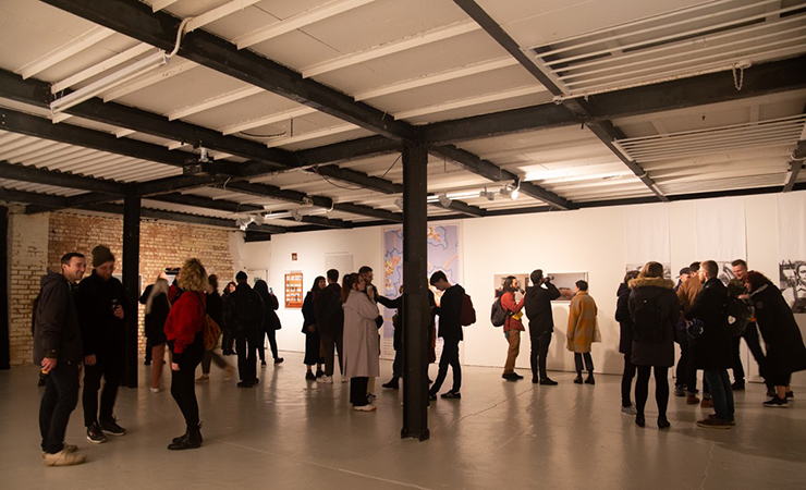 Visitors in the exhibition space with modern ceiling