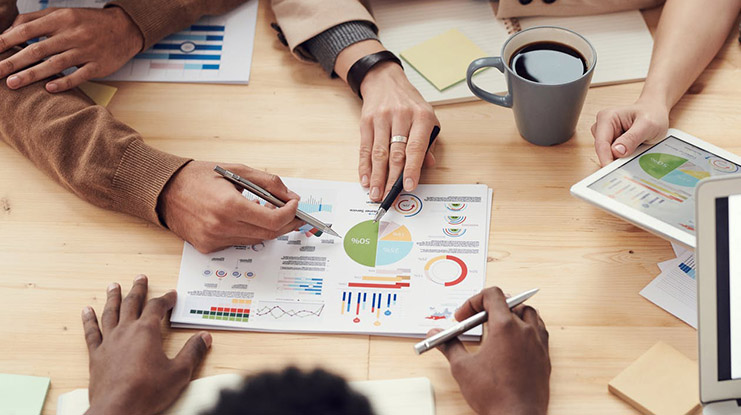 Hands on a table with graphs on paper