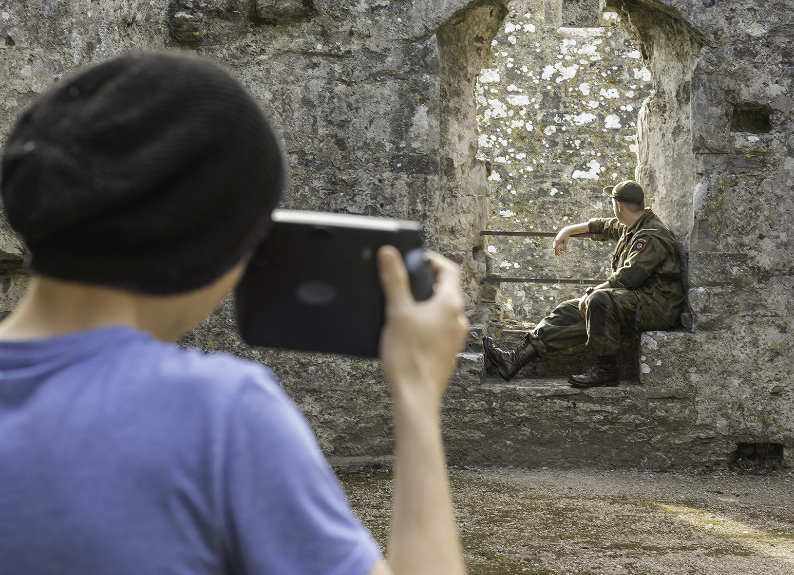 Young person taking photo of another person in uniform