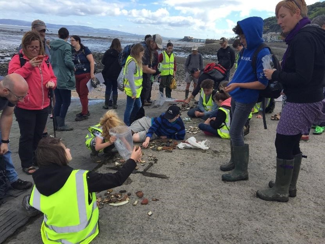 Local people looking at artefacts on the beach