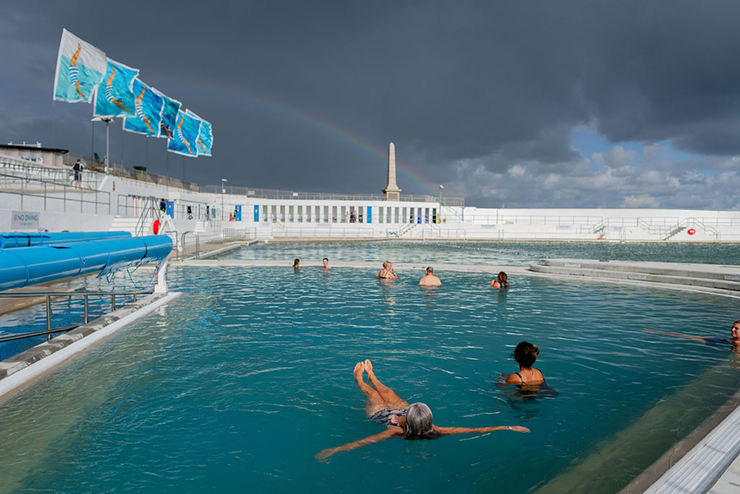 People using a lido with a rainbow overhead