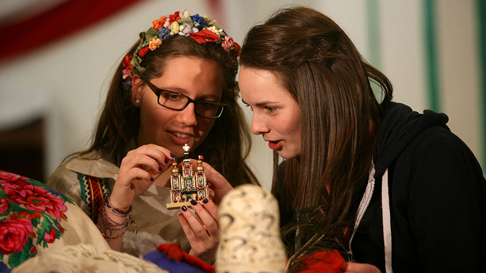 Two young women examining a figurine