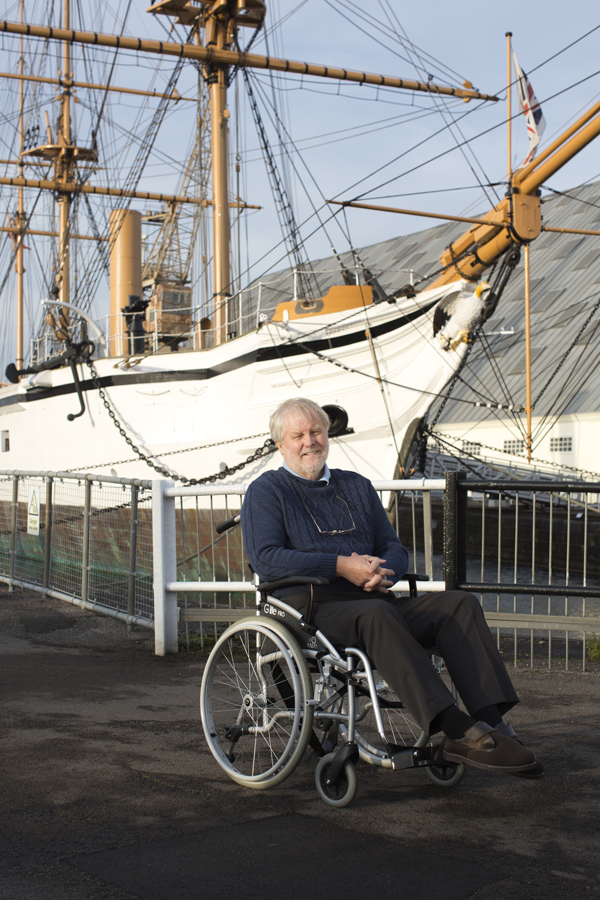 Tony at the Historic Dockyard Man in wheelchair in front of a ship