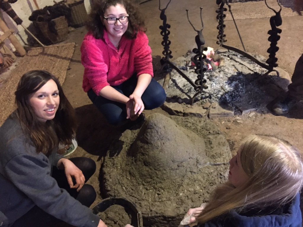 Volunteers from the Youth Forum with their bread oven Young women with an Iron Age bread oven