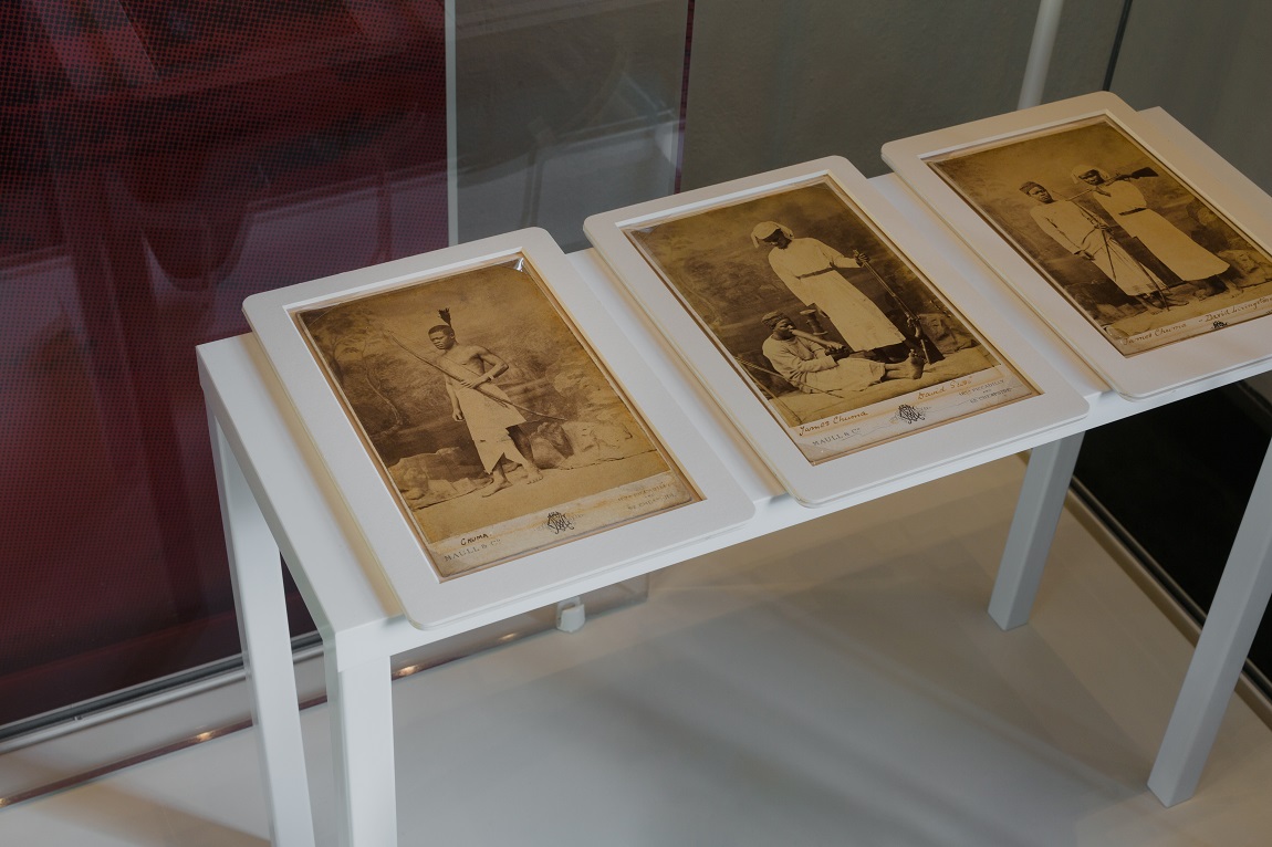 Two old black and white photographs of African people on display at an exhibition