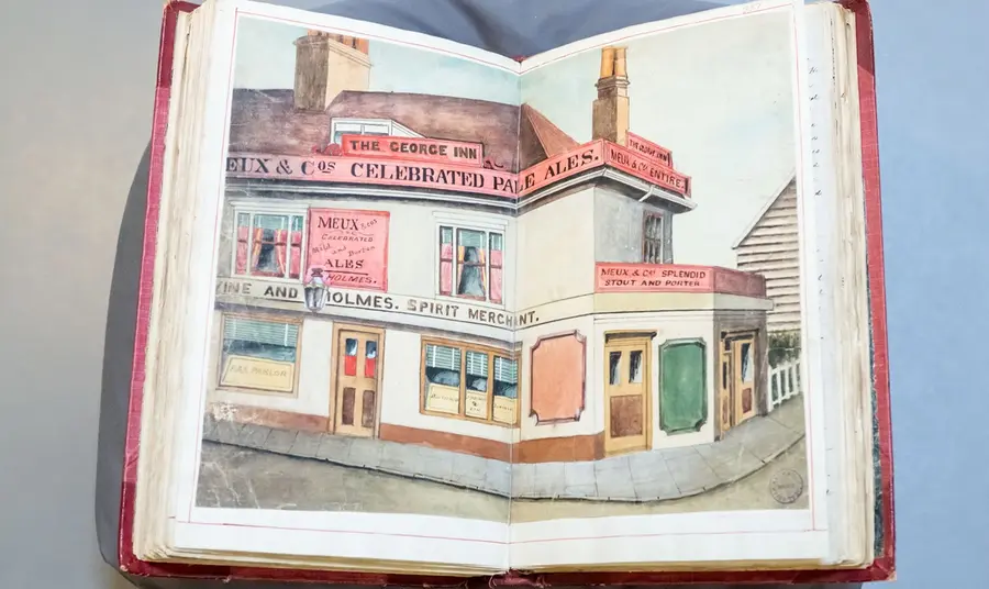 A large red book, open to a page depicting a painting of a historic Barking and Dagenham pub, captured in the early 20th century.