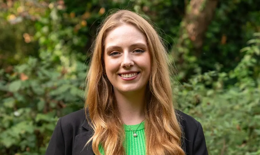 Lisa Manning standing in front of greenery