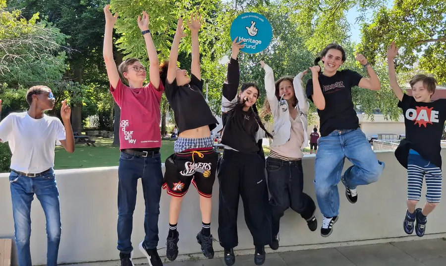 Young people jumping in the air celebrating their Heritage Fund grant to restore their Hall