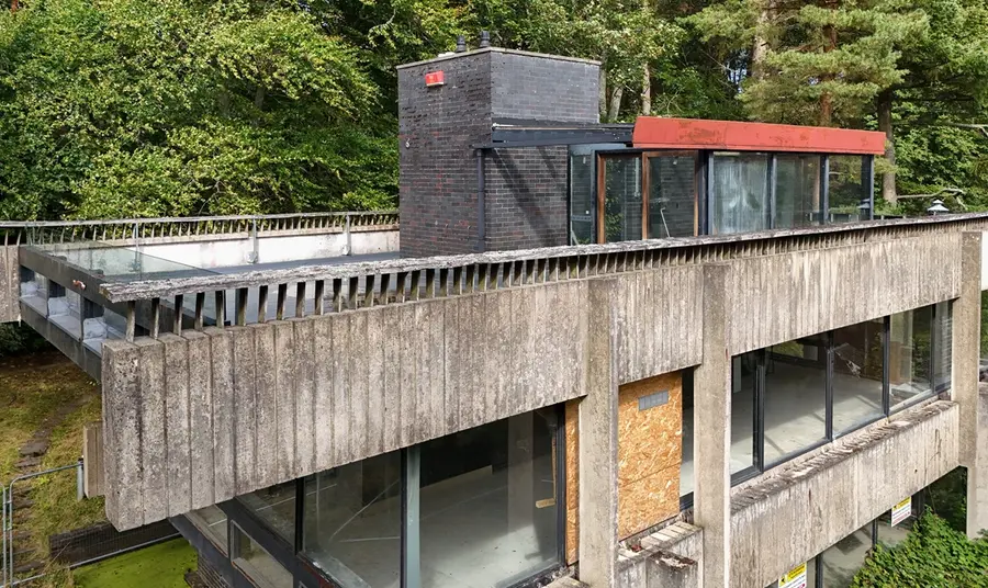 A view of the open top floor of the studio, with the woodland behind.