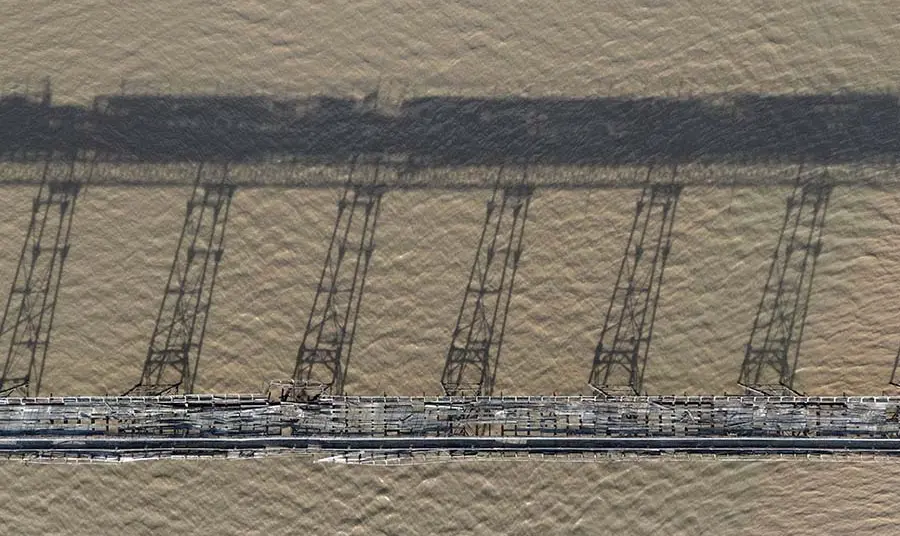 The bridge of Birnbeck Pier in a state of disrepair among the water.