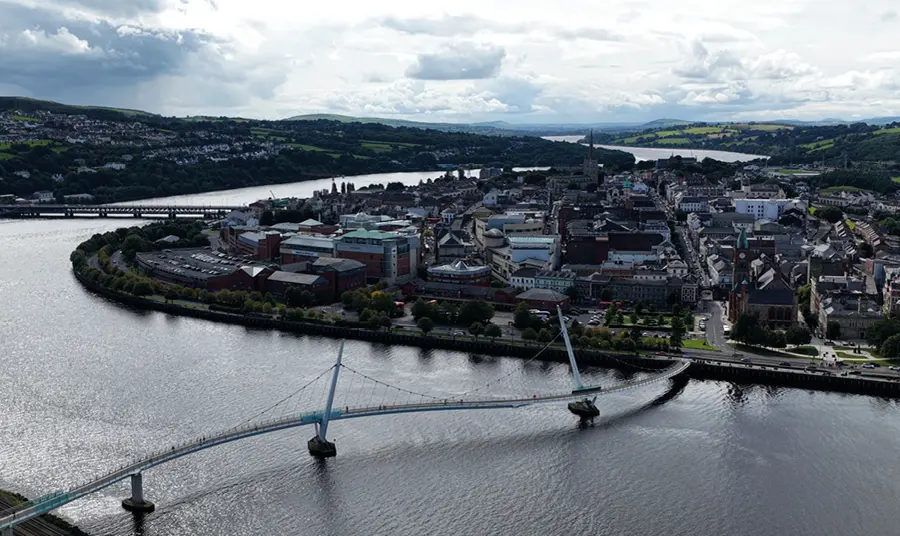 An aerial view of Derry/Londonderry showing the Peace Bridge and the River Foyle