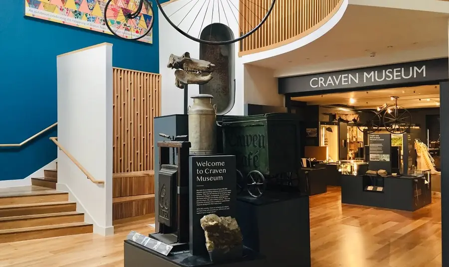 A museum space with various objects on display, like old clothing, bicycles and skulls and rocks