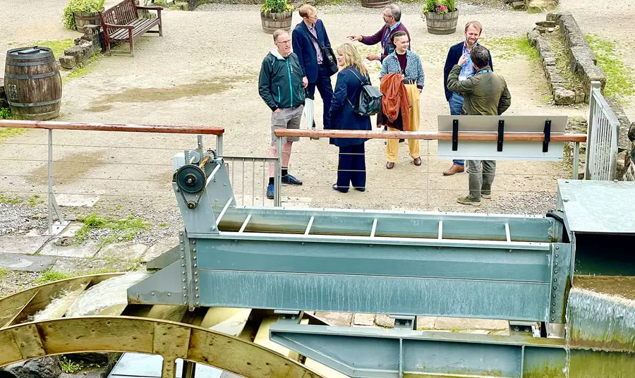 Visitors gather near to the replica waterwheel at Cromford Mills