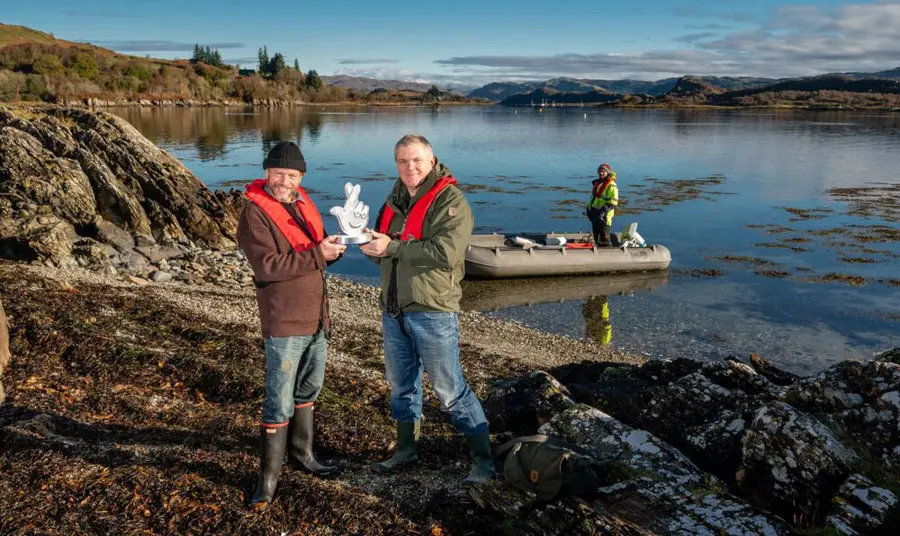 Danny being presented his award by Ray Mears on the shore of the loch.