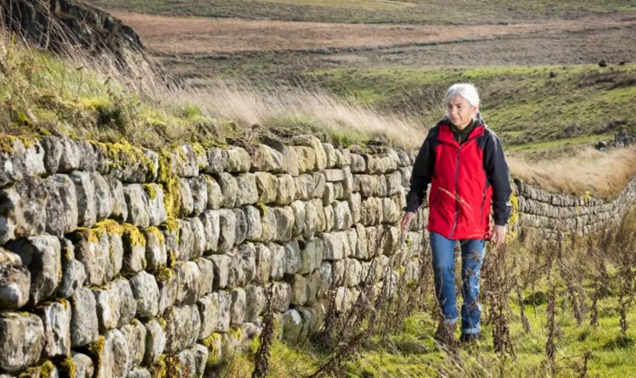 A person walks alongside part of Hadrian's Wall in Northumberland