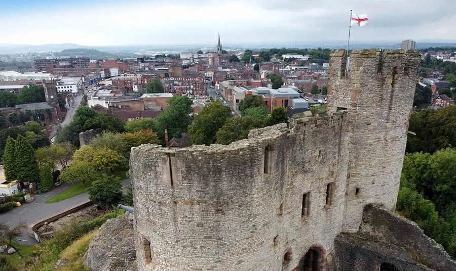 The thirteenth century keep of Dudley Castle, flying a cross of St. George, rises above the skyline of the town.