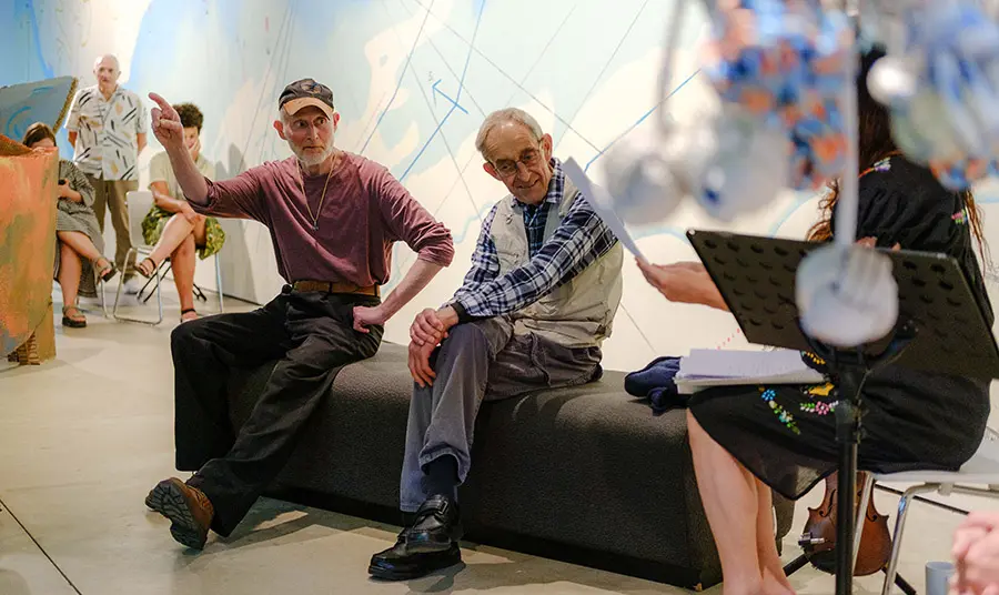 Two fishermen talking in an art gallery