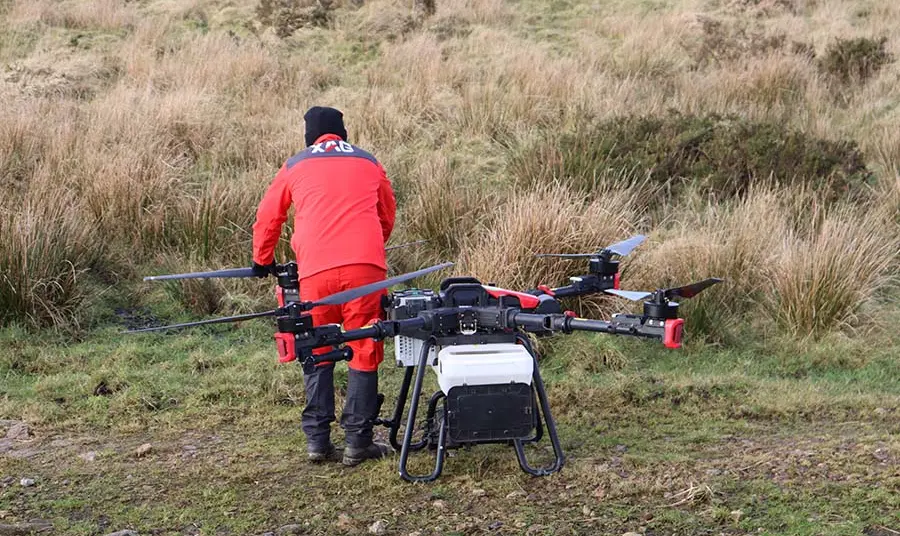 A large drone is on the ground with an operator exploring the machine.
