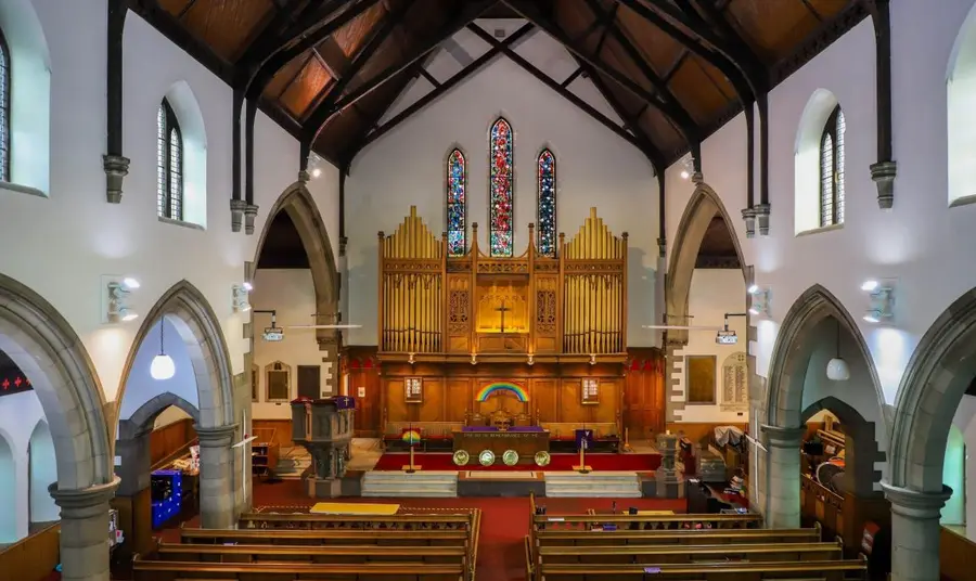 The interior of St. Andrews, Leith. An elevated view across the pews of St. Andrew's, towards the large organ and stained glass windows.