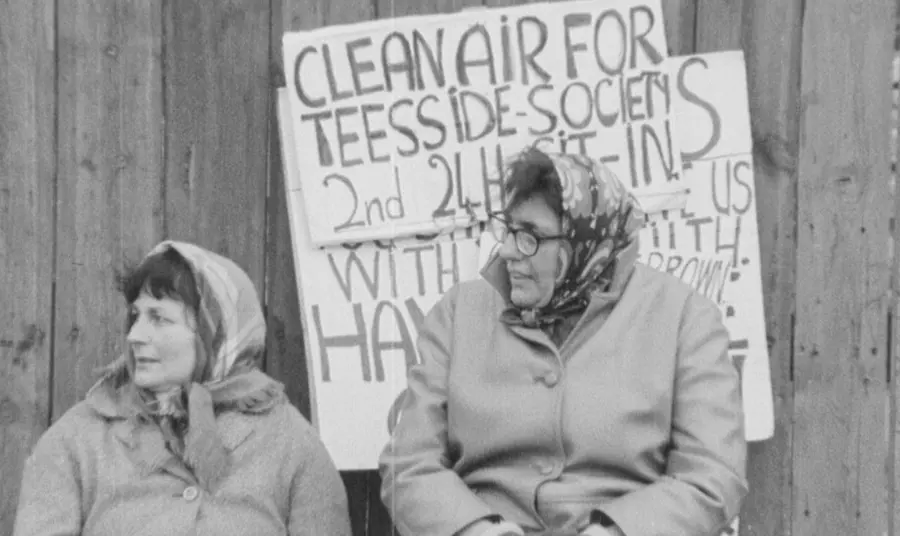 A film still from a 1968 clean air protest showing two women with protest signs