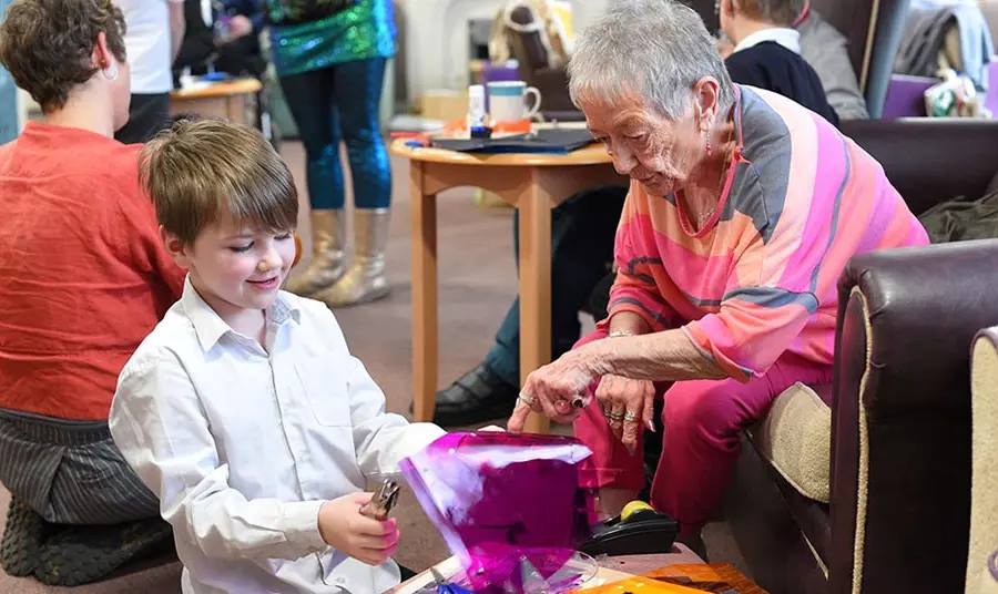 An older woman and a young child do craft activities together