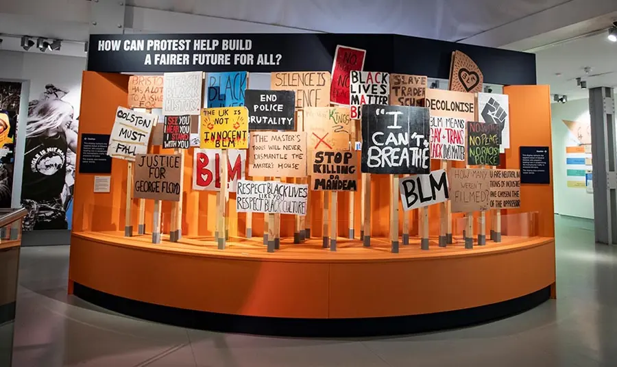 A museum display of black lives matter protest placards. The museum signage asks 'How can protest help build a fairer future for all?'